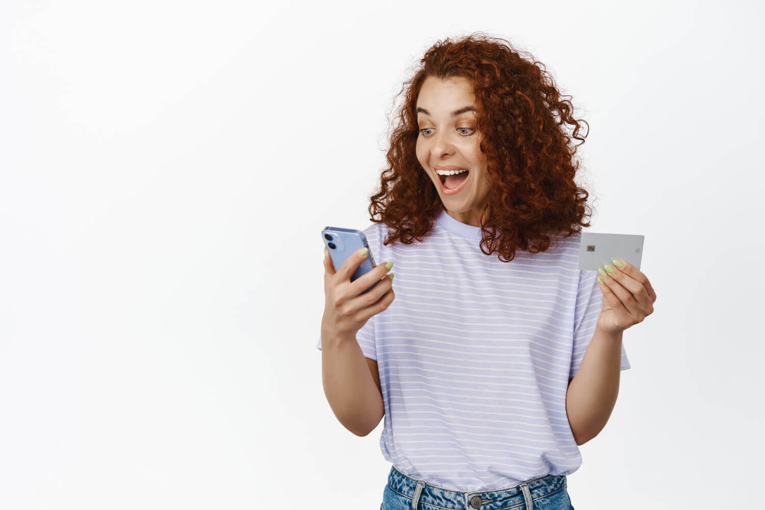 Mulher jovem sorrindo ao consultar celular e segurar cartão de crédito, celebrando a atualização do saldo do FGTS na 321bank